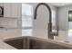 Stainless steel sink with modern faucet set in a white countertop and light backsplash at 1740 Standing Rock Cir, Oakland, FL 34787