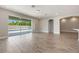 Spacious living room with wood-look tile floors, sliding glass doors to the pool area, and arched doorways at 1740 Standing Rock Cir, Oakland, FL 34787