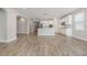 Spacious living area featuring wood-look tile flooring, an open layout, and a modern kitchen in the background at 1740 Standing Rock Cir, Oakland, FL 34787