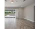 Bright and airy living room with wood-look tile floors, sliding glass doors to the pool area, and recessed lighting at 1740 Standing Rock Cir, Oakland, FL 34787