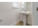 Stylish powder room featuring a pedestal sink and window at 1797 Archer Dr, Minneola, FL 34715
