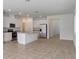 Open kitchen features stainless steel appliances, island with granite countertops, and tiled floors at 1797 Archer Dr, Minneola, FL 34715