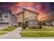 Beautiful two-story home featuring stone accents, well-manicured landscaping, and a brick-paved driveway at 1809 Tropical Palms Cir, Kissimmee, FL 34747