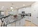 Bright kitchen with granite island, stainless appliances, and modern lighting fixtures at 1809 Tropical Palms Cir, Kissimmee, FL 34747