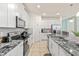 Modern kitchen features stainless steel appliances, granite countertops, and white cabinetry at 1809 Tropical Palms Cir, Kissimmee, FL 34747