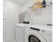 Bright laundry room with modern white washer and dryer, and convenient shelving for storage at 1809 Tropical Palms Cir, Kissimmee, FL 34747