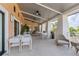 Inviting covered outdoor patio with stylish tables, chairs, and fans for comfortable dining and socializing at 1809 Tropical Palms Cir, Kissimmee, FL 34747