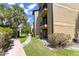 A view of the condo exterior with a sidewalk and lush tropical landscaping at 1908 Lake Atriums Cir # 3, Orlando, FL 32839
