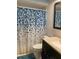 Updated bathroom features a tub and shower with a blue patterned shower curtain at 19430 Sw 100Th Loop, Dunnellon, FL 34432
