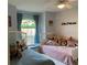 Bright bedroom with flamingo-themed window and decorative stuffed animals at 19430 Sw 100Th Loop, Dunnellon, FL 34432