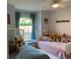 Charming bedroom with twin beds, decorative window, plush pillows, and a ceiling fan at 19430 Sw 100Th Loop, Dunnellon, FL 34432