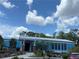 Low-rise blue building with white trim and landscaping in front at 19430 Sw 100Th Loop, Dunnellon, FL 34432
