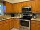 Well-lit kitchen featuring stainless steel appliances, light cabinets, and granite countertops at 19430 Sw 100Th Loop, Dunnellon, FL 34432