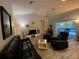 Comfortable living room with a ceiling fan, modern furniture and view of the screened pool area at 19430 Sw 100Th Loop, Dunnellon, FL 34432