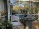 Outdoor patio with a pool, plants and seating with a view into the surrounding wooded landscape at 19430 Sw 100Th Loop, Dunnellon, FL 34432