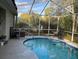 Relaxing screened-in pool with lounge chairs surrounded by lush landscaping creates a private oasis at 19430 Sw 100Th Loop, Dunnellon, FL 34432