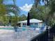 Community pool area featuring a variety of seating around the pool and lush tropical landscaping at 19430 Sw 100Th Loop, Dunnellon, FL 34432