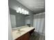 Well-lit bathroom with a double vanity and combination shower and tub at 226 Canna Dr, Davenport, FL 33897