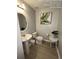 Well-lit half bathroom featuring a pedestal sink, toilet, and decorative artwork and plants at 226 Canna Dr, Davenport, FL 33897