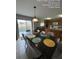 Dining area featuring a long table, seating for six, and views of the pool through sliding glass doors at 226 Canna Dr, Davenport, FL 33897