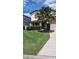 Charming two-story home featuring lush green lawn, mature landscaping, and a classic architectural design at 226 Canna Dr, Davenport, FL 33897