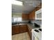 Functional kitchen featuring wooden cabinets, a stainless steel sink, and white appliances at 226 Canna Dr, Davenport, FL 33897