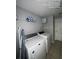 Functional laundry room with a washer, dryer, and overhead shelving for storage at 226 Canna Dr, Davenport, FL 33897