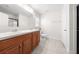 Bright bathroom featuring double sinks, wood cabinets, tile flooring and walk-in shower with black trim at 236 Miles Ct, Davenport, FL 33837