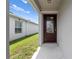 Elegant front door with decorative glass, inviting entrance into a well-maintained home with a lush green lawn at 236 Miles Ct, Davenport, FL 33837