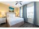 Bright bedroom featuring a king bed, ceiling fan, wood-look floors, and side tables at 2923 Castaway Ln, Kissimmee, FL 34747