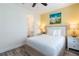 Bright bedroom featuring a king bed, wood-look floors, yellow accent wall, ceiling fan and ensuite bathroom at 2923 Castaway Ln, Kissimmee, FL 34747