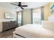 Bright bedroom featuring a king bed, ceiling fan, wood-look floors, a dresser and Margaritaville themed TV at 2923 Castaway Ln, Kissimmee, FL 34747