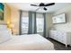 Bright bedroom featuring a king bed, ceiling fan, wood-look floors, a dresser and Margaritaville themed TV at 2923 Castaway Ln, Kissimmee, FL 34747