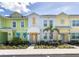 Brightly painted townhomes with colorful accents and well-maintained landscaping create a cheerful street view at 2923 Castaway Ln, Kissimmee, FL 34747