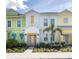 Colorful townhomes with a small palm tree and beautiful flower beds create a serene, tropical street view at 2923 Castaway Ln, Kissimmee, FL 34747