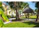 Tropical grounds featuring lush landscaping, walking paths, and a tiki hut at 2923 Castaway Ln, Kissimmee, FL 34747
