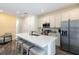 Bright kitchen with stainless steel appliances, a breakfast bar, and white cabinets at 2923 Castaway Ln, Kissimmee, FL 34747