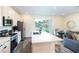Modern kitchen with stainless steel appliances, a spacious island, and an open view to the dining area at 2923 Castaway Ln, Kissimmee, FL 34747