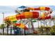 View of the water park slide featuring orange, yellow, white and green slides, palm trees, and blue sky at 2923 Castaway Ln, Kissimmee, FL 34747