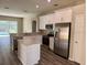 Bright kitchen with stainless appliances, white cabinets, and center island at 307 Dalton Ct, Davenport, FL 33897