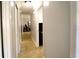 Hallway with base molding and tan tile leading to rooms with views of mounted TVs at 3223 Dragoon Pl, Orlando, FL 32818