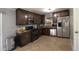 Spacious kitchen with dark cabinets, granite countertops, and stainless steel appliances, offering ample storage at 3223 Dragoon Pl, Orlando, FL 32818