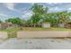 Backyard featuring a shed, trees, grass, and a fenced yard with a concrete patio and border wall at 324 Sir Lawrence Dr, Sanford, FL 32773