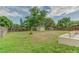 Backyard featuring a shed, trees, grass, and a fenced yard with a concrete patio and border wall at 324 Sir Lawrence Dr, Sanford, FL 32773