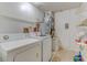 Functional laundry room with washer, dryer, water heater, storage shelving, and utility hookups at 324 Sir Lawrence Dr, Sanford, FL 32773