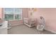 Lovely Bedroom with pink walls, white crib, and baby swing create a soothing environment at 3256 Merton Aly, Orlando, FL 32808