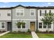 Charming townhome with a welcoming yellow front door and fresh, modern landscaping at 3256 Merton Aly, Orlando, FL 32808
