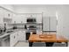 Modern kitchen featuring white cabinets, granite countertops, and stainless steel appliances at 3256 Merton Aly, Orlando, FL 32808