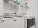 Bright laundry room featuring a modern washer and dryer set with convenient shelving at 3256 Merton Aly, Orlando, FL 32808