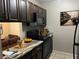 Modern kitchen with dark cabinetry, granite countertops, and stainless steel appliances at 3270 S Semoran Blvd # 15, Orlando, FL 32822